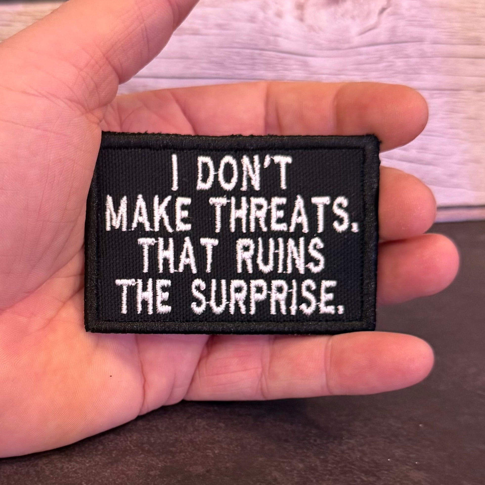 I Don't Make Threats, That Ruins The Surprise Funny Morale Patch, 2x3" | Made in USA | VELCRO® Brand Hook Backing
