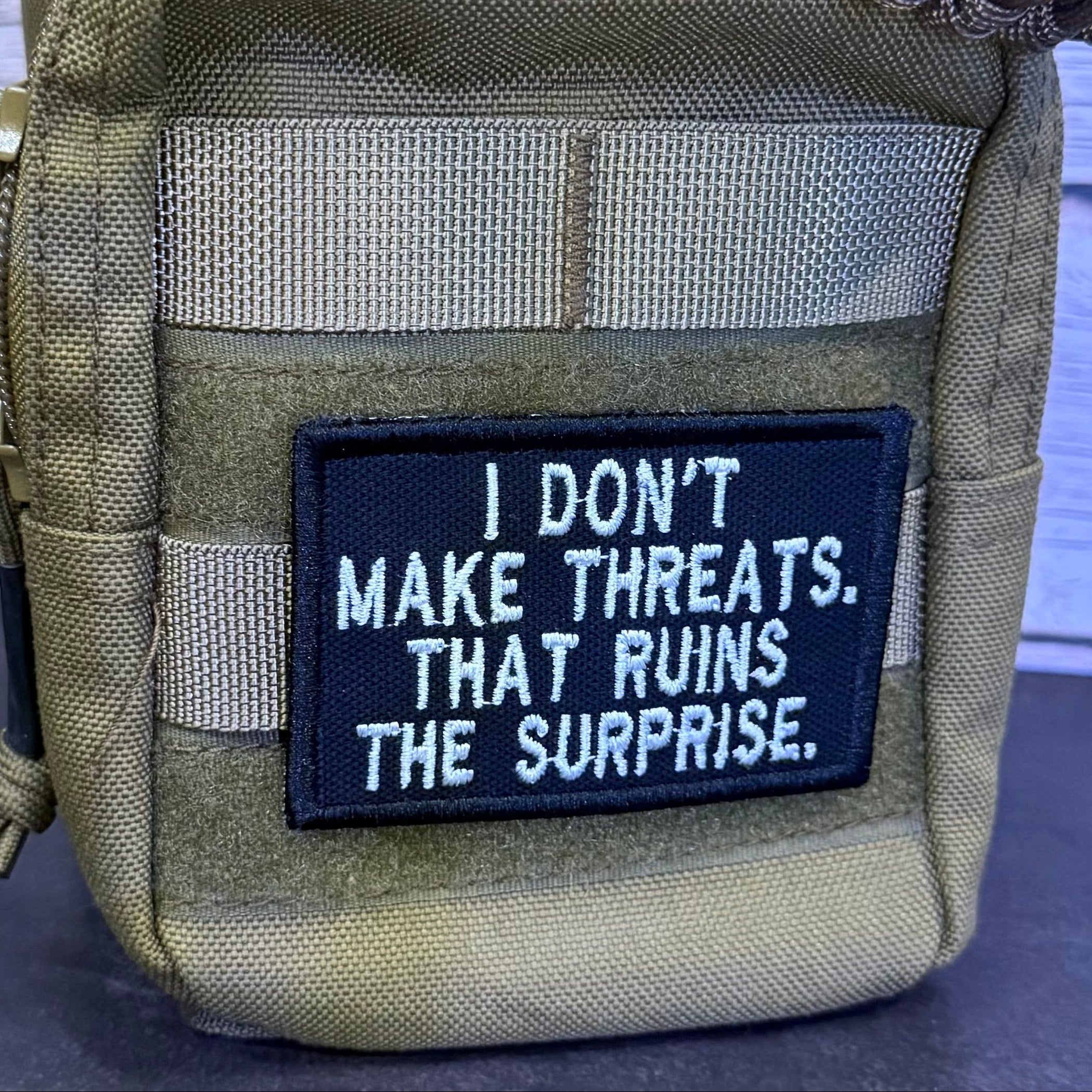 I Don't Make Threats, That Ruins The Surprise Funny Morale Patch, 2x3" | Made in USA | VELCRO® Brand Hook Backing