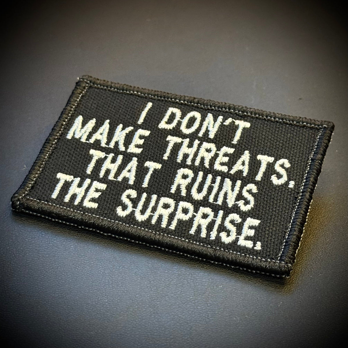 I Don't Make Threats, That Ruins The Surprise Funny Morale Patch, 2x3" | Made in USA | VELCRO® Brand Hook Backing